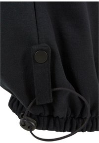 Sort sweatshirtmanchet med justerbar snøre, der har et tekstureret stof og en knaplukket strop til at sikre pasformen.