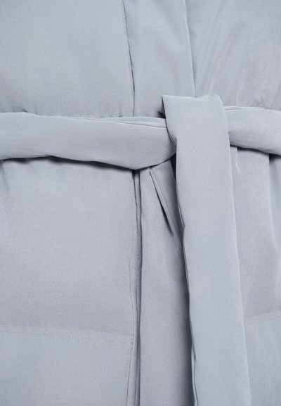 Svijetlosiva puffer jakna s pojasom u struku, glatkom teksturom tkanine, horizontalnim šavovima i bočnim džepovima.