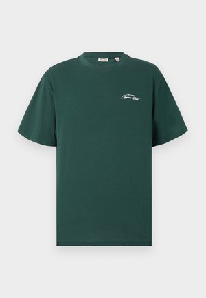 Groen katoenen T-shirt met korte mouwen, ronde hals en klein wit logodetail op de borst. Gladde textuur en een losse pasvorm.