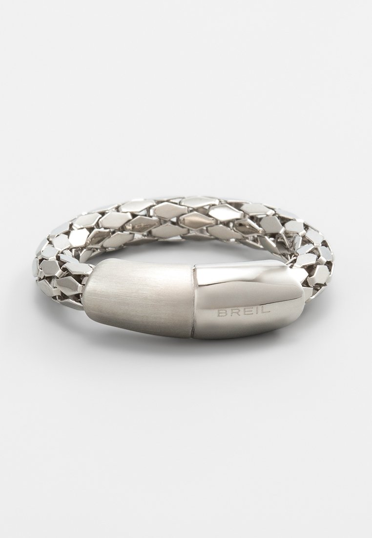 Silberfarbener geflochtener Armband mit einem glatten, runden Verschluss. Das Material hat polierte und gebürstete Oberflächen. Mit "BREIL" gekennzeichnet.