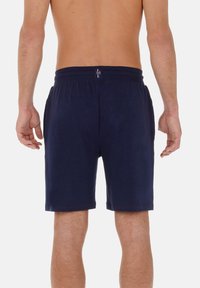 Pantalones cortos azul marino con cintura elástica, que incluyen bolsillos laterales y detalles de costura en contraste. Confeccionados en una tela suave y ligera.