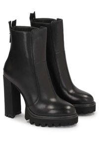 Stivaletti in pelle nera alla caviglia con tacco spesso e suola rigata. Presentano una finitura liscia, zip laterali e punte arrotondate.