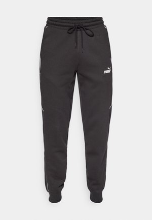 Svart joggebukser laget av myk fabric, med elastisk midje og snøring, hvite striper på siden, og en liten logo på låret.