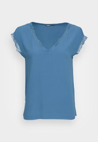 Top corto blu con scollo a V. Il colletto e i bordi delle maniche sono accentuati da pizzo. Tessuto morbido, vestibilità comoda e orlo dritto.