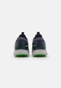 Pantofi sport bleumarin cu accente verzi, având o talpă din cauciuc rezistentă și un spate texturat pentru aderență. Design ușor, cu mânere de tragere.