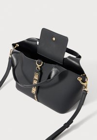Zwarte leren handtas met gouden hardware, open klep met drukknoop en een "LOVE MOSCHINO" logo tag op de voorkeursband.