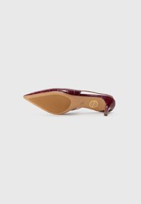 Burgundy patent leather korkokenkä, jossa on terävä kärki, teksturoitu pinta, joka jäljittelee nahkaa, ja hoikka korko.