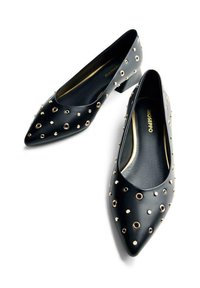 Bailarinas negras de punta afilada hechas de cuero suave, con tachuelas circulares doradas en la parte superior. Tacón pequeño; interior forrado en negro.