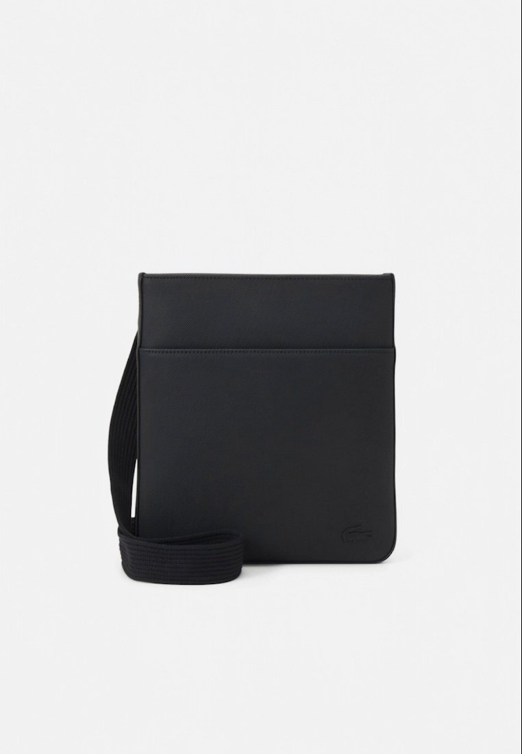 Sac bandoulière rectangulaire noir en cuir texturé, avec une poche avant, une sangle réglable et un logo discret dans le coin inférieur.