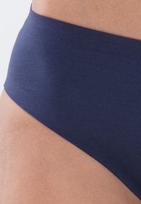 Navy modrá bikiny spodní část vyrobená z bavlněné směsi, s hladkým povrchem, širokým páskem a minimalistickým designem bez viditelného kovového zapínání nebo vzorů.