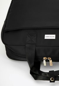 Czarna torba na laptopa z nylonu o gładkiej fakturze, z zamknięciem na zamek, podwójnymi złotymi suwakami oraz plecionym uchwytem do noszenia.