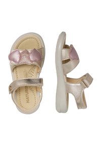 Sandali dorati con dettagli a forma di cuore rosa, cinturini regolabili e suola texturizzata. Realizzati in materiale sintetico con una finitura liscia.