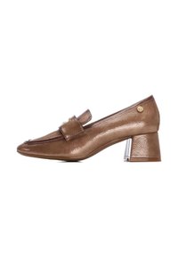 Zapato de charol marrón con punta redonda, acento de correa y tacón bloque geométrico. La superficie texturizada añade interés visual.