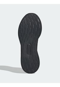 Černá podrážka tenisky s texturovanou, vzorovanou gumou pro lepší přilnavost; má střední drážku pro větší pružnost a odolnost.