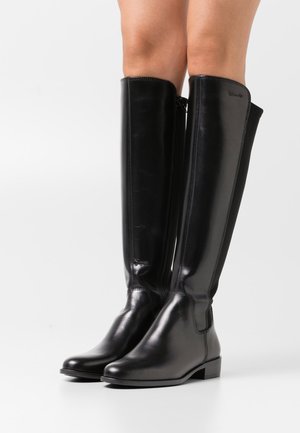 Botas altas de cuero negro con un diseño elegante, tacón plano, cremallera lateral y textura suave. Sin patrones ni acentos visibles.