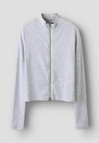 Giacca grigia cropped con zip, dalla texture a costine, colletto rialzato e maniche lunghe. Presenta una chiusura frontale con zip e un design minimalista.