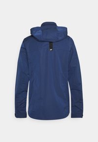 Mörkblå jacka med huva, tillverkad av lätt material. Har en central svart etikett och elastiska muddarna. Ren, minimalistisk design.