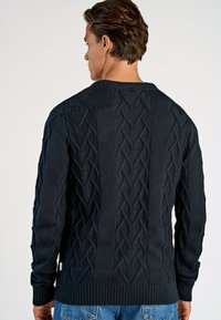 Marineblauer Strickpullover mit strukturiertem Zopfmuster, gerippten Bündchen und Saum; aus einem weichen Stoff, der sich gut zum Layering eignet.