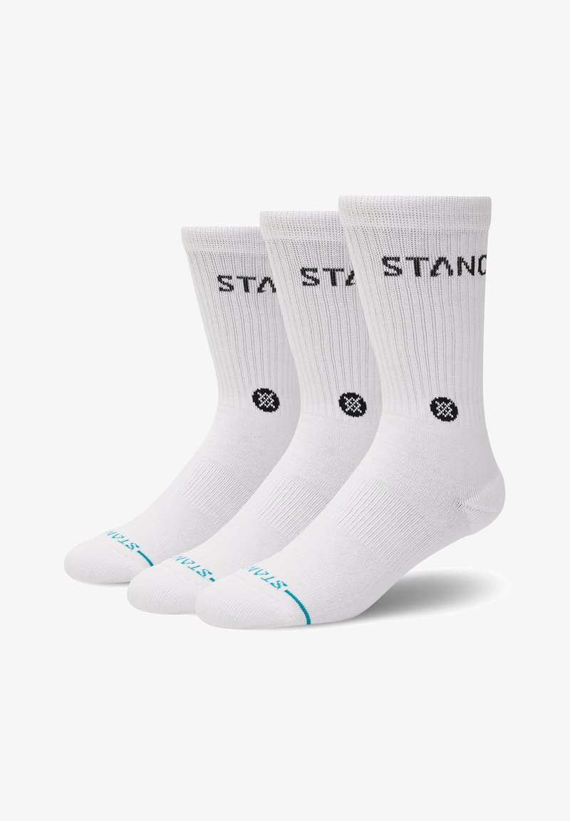 Tre paia di calzini bianchi tipo crew con testo nero "STAN" in alto e un piccolo logo circolare nero sotto il testo.