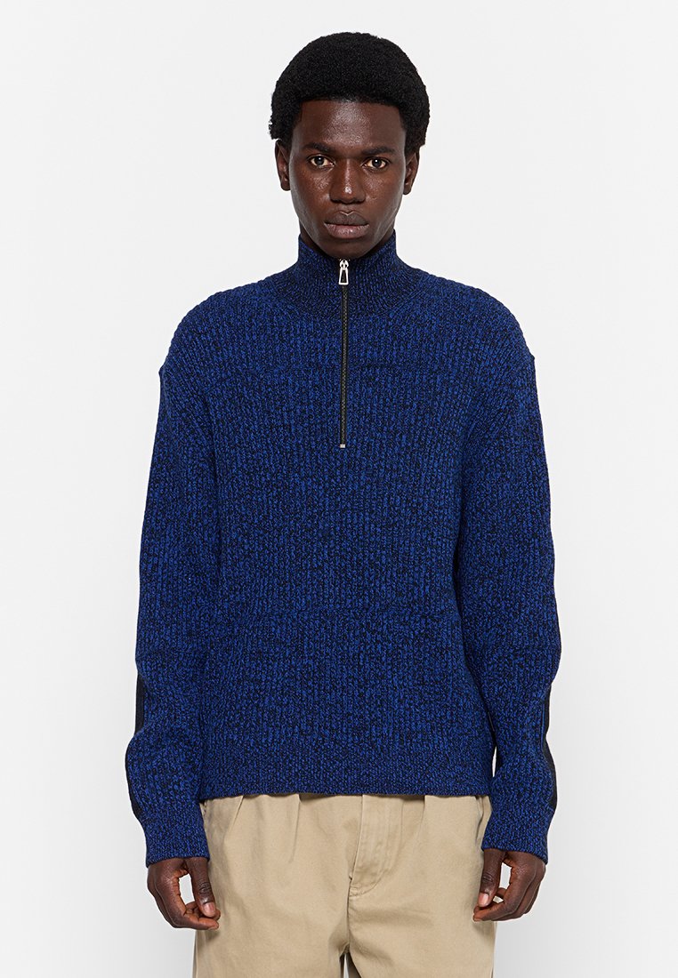 Blauer gestrickter Pullover mit hohem Kragen und Viertel-Reißverschluss. Verfügt über eine gerippte Textur und schwarze Seitenpaneele, die eine lockere Passform bieten.