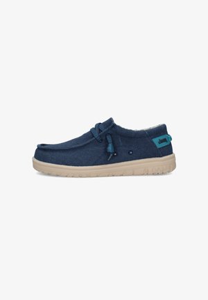 Scarpa casual slip-on blu navy con suola beige, lacci elastici regolabili e logo Jeep sulla linguetta del tallone, vista laterale.