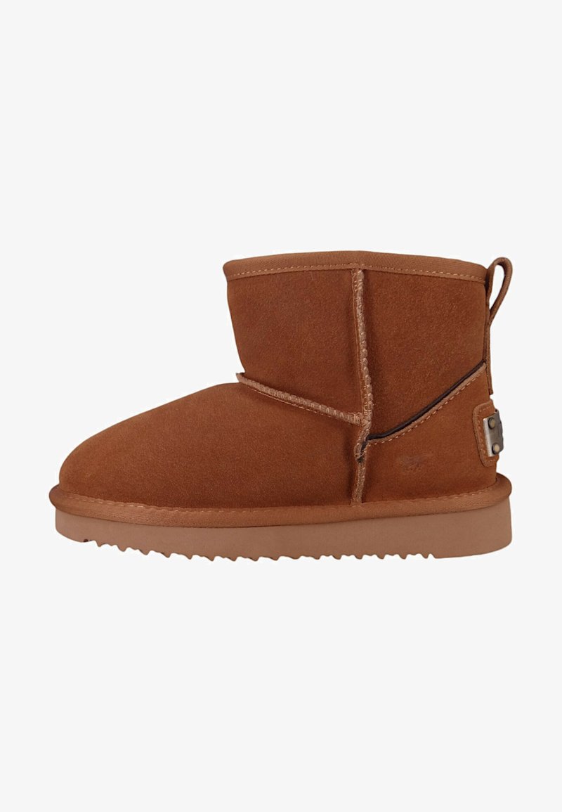 Stivale alla caviglia in suede marrone con punta arrotondata, cuciture a vista e suola corta e robusta. Presenta un tab posteriore per la presa e un sottile dettaglio in metallo.