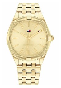 Gold-tone wristwatch with a textured dial featuring thin hour markers, a date display, and a linked bracelet design. Red, white, and blue accents.