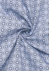 Tessuto azzurro chiaro con motivo floreale e contorni blu scuro. Il design include motivi simmetrici e superfici texture.