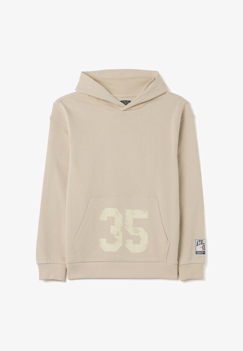 Sudadera beige hecha de una tela suave, con un bolsillo frontal, un "35" desvanecido en crema en la parte delantera y una etiqueta deportiva en la manga.