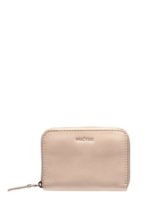 Beżowy skórzany portfel zapinany na zamek błyskawiczny, z wytłoczonym napisem „MAÎTRE” na przodzie oraz skórzanym uchwytem na suwaku.