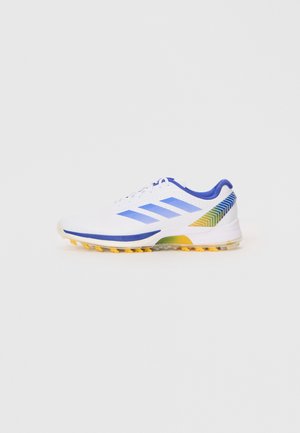 White athletic shoe with blue accents, featuring three stripes on the side, a textured upper, and a yellow outsole with cleats.