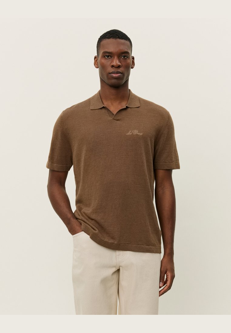 Bruine kortekleurige polo met korte mouwen, gemaakt van zachte stof, met een klassieke kraag en een subtiele geborduurde logo op de linkerkant van de borst.