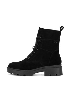 Czarny zamszowy botek za kostkę z okrągłym noskiem, sznurowanym przodem i grubą czarną gumową podeszwą. Posiada pętelkę z tyłu oraz logo na boku.
