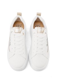 Sneaker bianche con esterno in pelle liscia, punta rotonda, lacci piatti, dettagli dorati e una piccola linguetta sul retro.