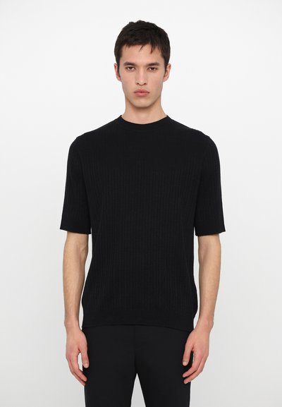 Pulover scurt, din tricot, de culoare neagră, cu mâneci scurte, textură ribb, decolteu rotund și croi lejer. Material neted cu o strălucire subtilă.