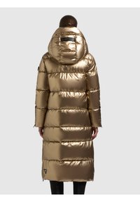 Langer, glänzender goldener Steppmantel mit Kapuze, gestepptem Design und schwarzem Etikett auf der Rückseite. Verfügt über Reißverschlusstaschen und eine leicht taillierte Passform.