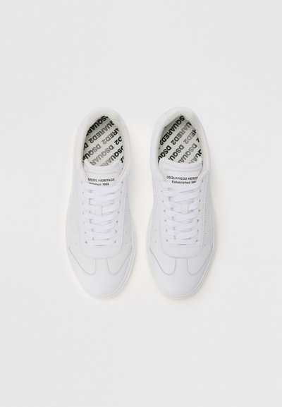 Baskets blanches avec un dessus en cuir lisse, un bout rond, des détails perforés et des lacets plats. Les semelles intérieures présentent un imprimé logo noir.