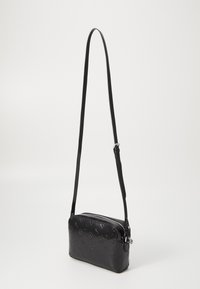 Borsa a tracolla nera in pelle goffrata, forma rettangolare, chiusura a zip e tracolla regolabile, con delicati motivi logo.