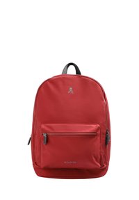 Mochila de nailon roja con un gran compartimento principal, bolsillo frontal con cremallera y detalles en cuero negro. Presenta un logo de calavera en la parte superior.