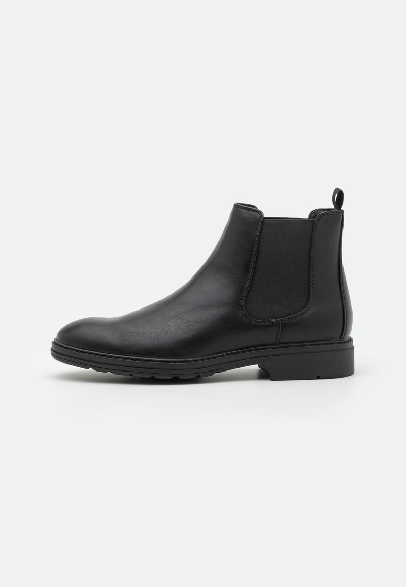 Botte Chelsea en cuir noir avec panneaux élastiques sur les côtés, languette au talon, talon bas et semelle en caoutchouc texturée.