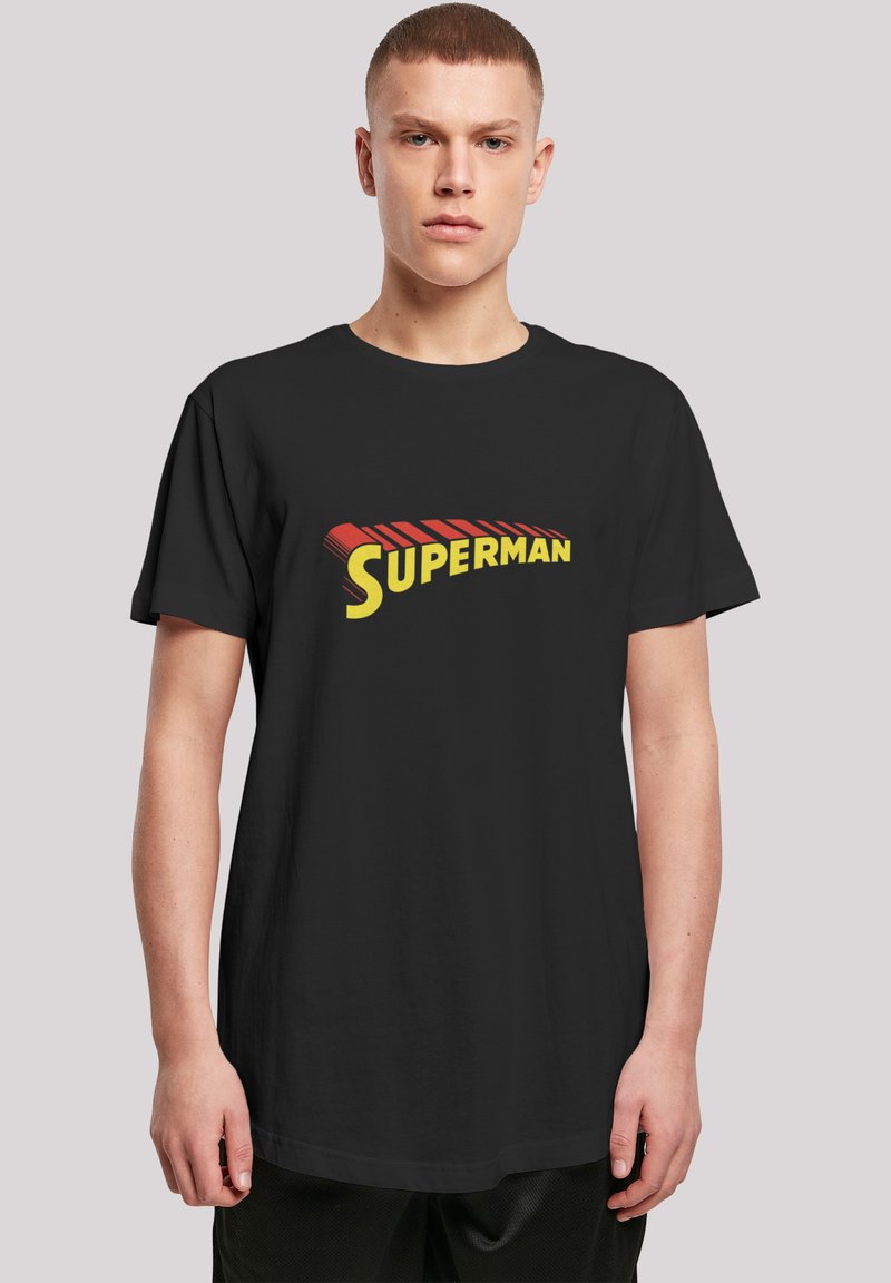 Black t-shirt featuring a bold yellow and red "SUPERMAN" logo. Made of smooth fabric with short sleeves and a relaxed fit.