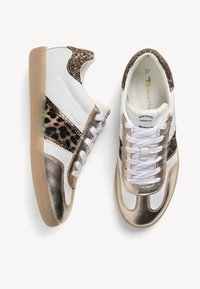 Damskie sneakersy o eleganckim designie, wykonane z białej skóry, z akcentami w złotym kolorze i panterkowym wzorem oraz brokatowym obcasem. Płaska gumowa podeszwa.