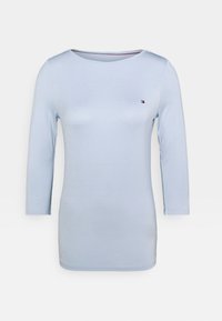 Camicia fitted a maniche lunghe di colore azzurro chiaro, con scollatura rotonda e piccolo logo ricamato rosso, bianco e blu sul lato sinistro del petto.