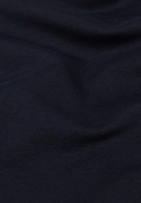 Dunkel marineblaues Gewebe mit feiner gerippter Textur und subtilen Falten, die sanfte Schatten und Lichtreflexe erzeugen.