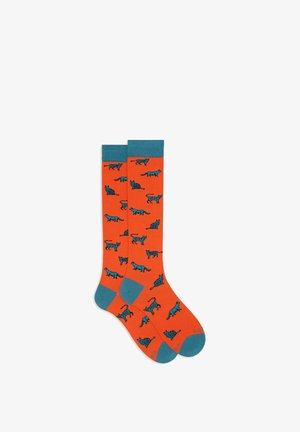 Orange socks featuring a pattern of blue cats in various poses, with teal cuffs and toe accents. Made of a soft, textured fabric.