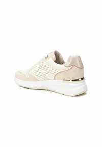 Zapatillas de mujer que presentan una combinación de cuero crema y beige, perforaciones texturizadas, acentos metálicos y una suela blanca acolchada.