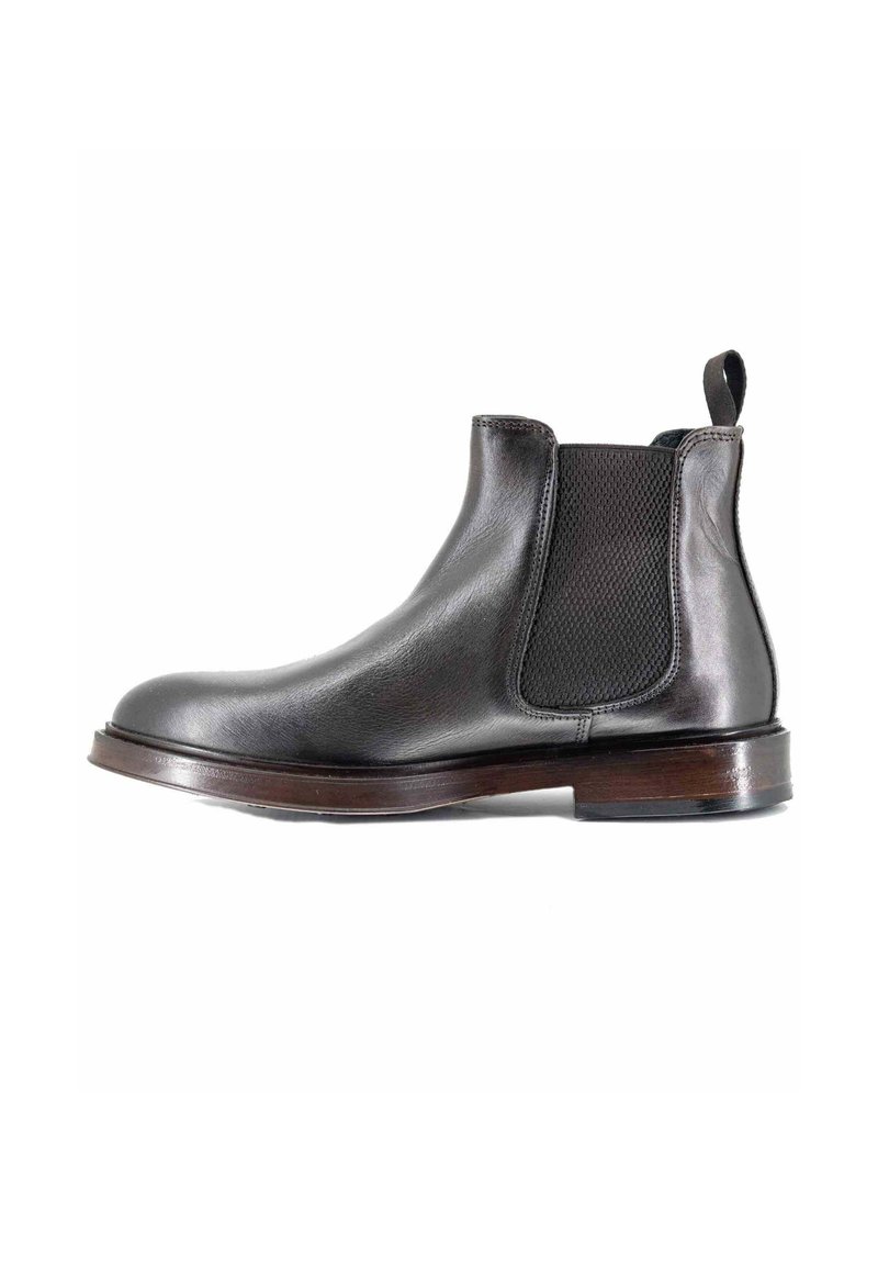 Stivale Chelsea in pelle nera con pannelli laterali elasticizzati, punta arrotondata, tacco impilato e linguetta. Finitura liscia con una silhouette elegante.