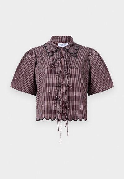 Top corto in tessuto a quadri rosso e nero, con maniche a sbuffo, orlo scallop, legature frontali e dettagli in pizzo nero attorno al collo.