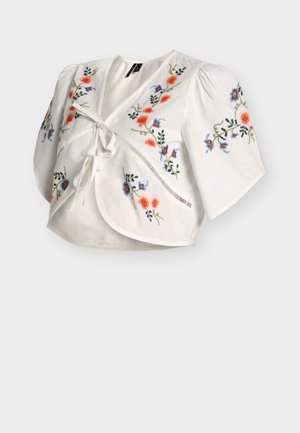 Hvid cropped bluse med pufærmer, bindelukning foran og farverig blomsterbroderi foran og på ærmerne.