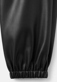 Tessuto in finta pelle nera, testurizzato, con polsini arricciati. Il materiale ha una finitura liscia e una leggera lucentezza, che mette in evidenza un design elegante.